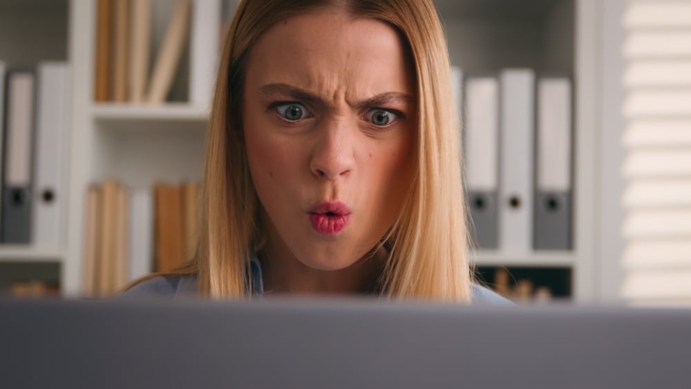 A woman sees something concerning on her computer screen