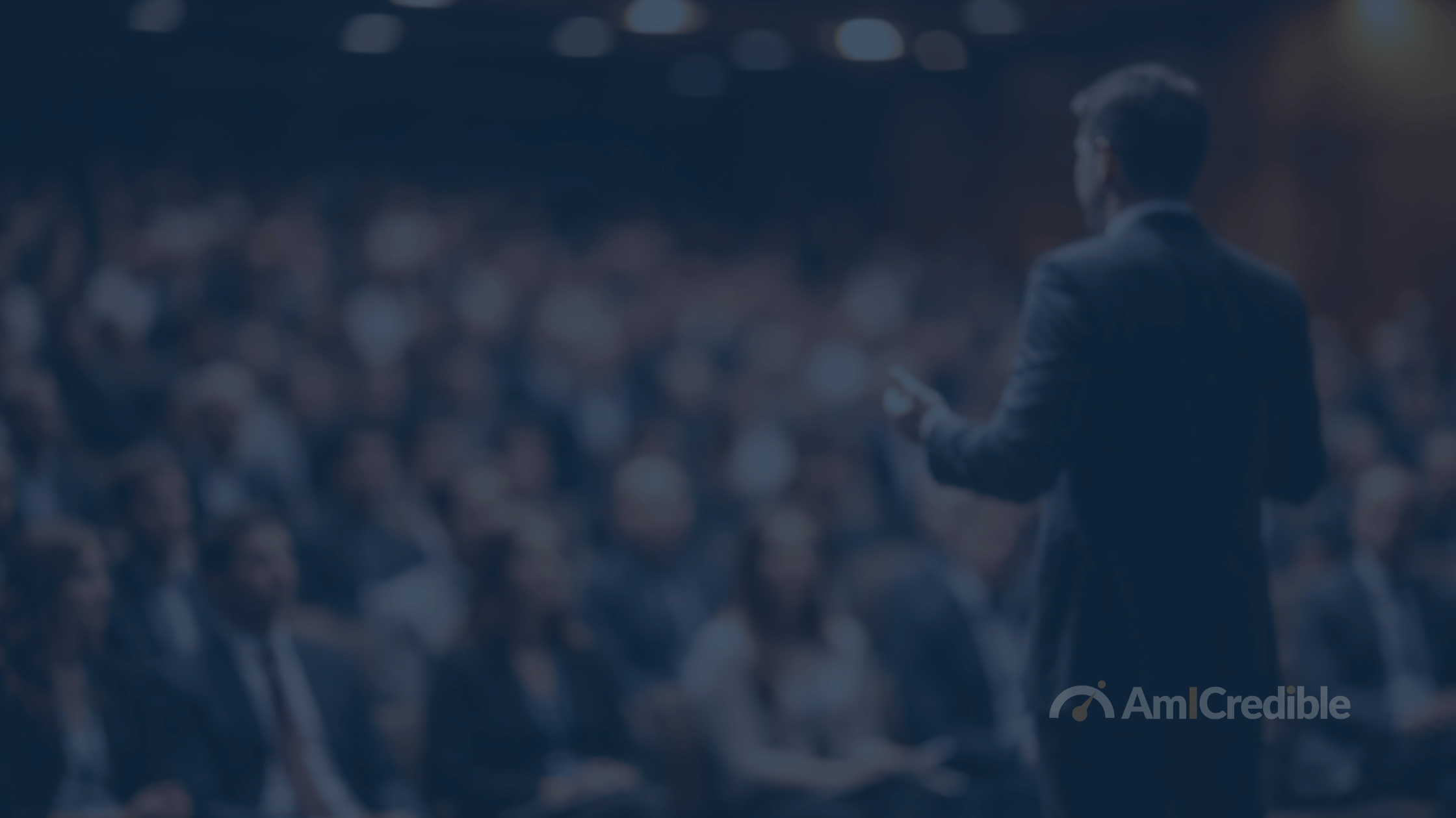 Man on stage speaking to an audience